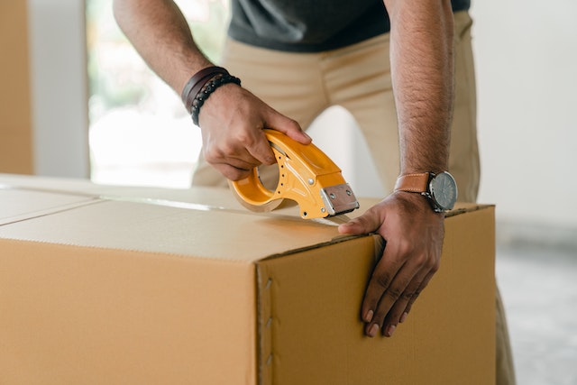 image-1 | Specialized Memphis Cropped image of a person taping a moving box closed