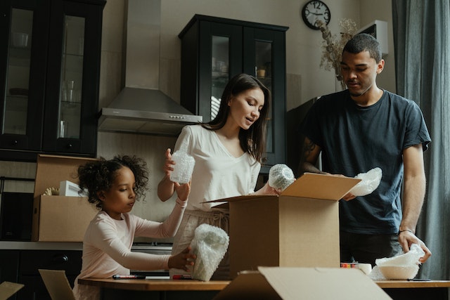 Family of three packing moving boxes together | Specialized Memphis Family of three packing moving boxes together
