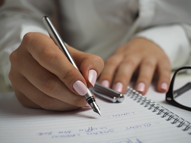 Person with pink nail polish using a fountain pen to write notes | Specialized Memphis Person with pink nail polish using a fountain pen to write notes