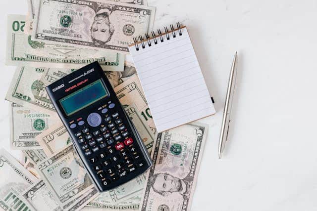 pexels-karolina-grabowska-4386373 3 | Specialized Memphis a calculator, notepad, and pen on top of a pile of cash