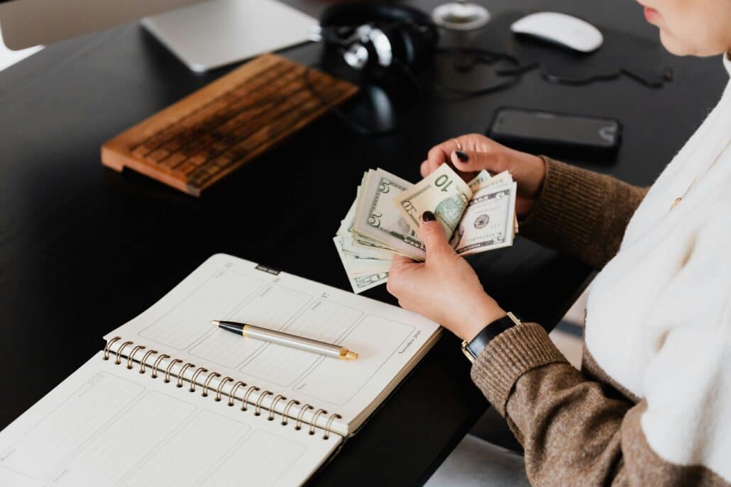 pexels-karolina-grabowska-4475527 | Specialized Memphis someone counting cash at a desk with an open notebook in front of them