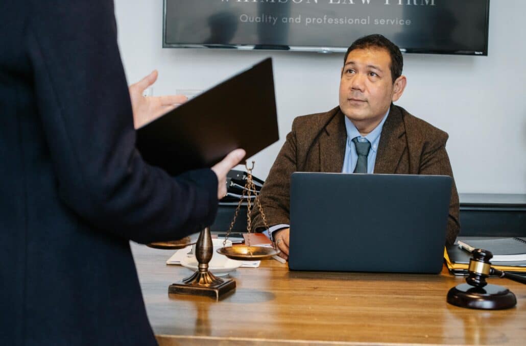 pexels-sora-shimazaki-5668798 | Specialized Memphis someone at a desk with an open laptop, gavel, and scales of justice
