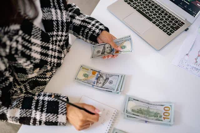 person counting money with notebook and pen | Specialized Memphis person counting money with notebook and pen